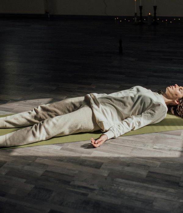 Woman meditating in a yoga pose with gentle light.